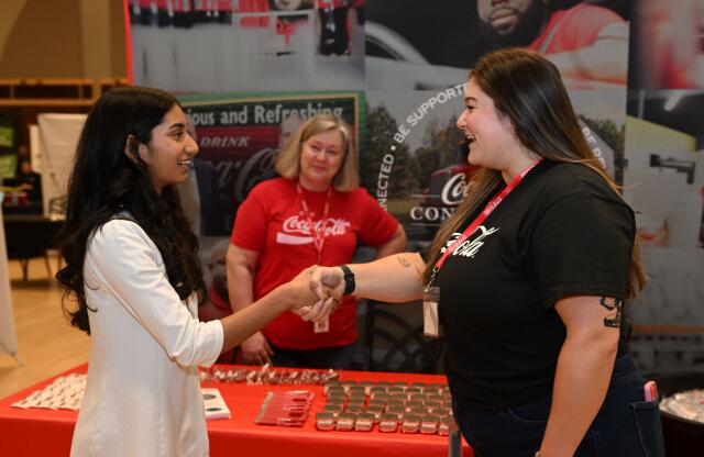 A student networking with employer at career fair