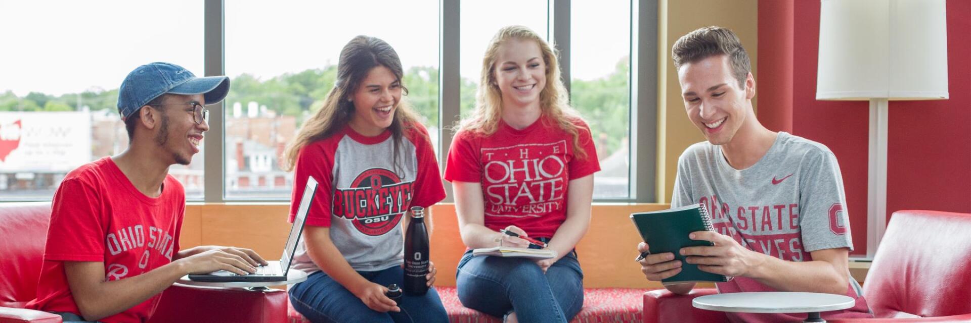 Four students sitting together smiling