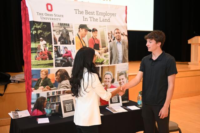 Student and employer shaking hands at a career fair