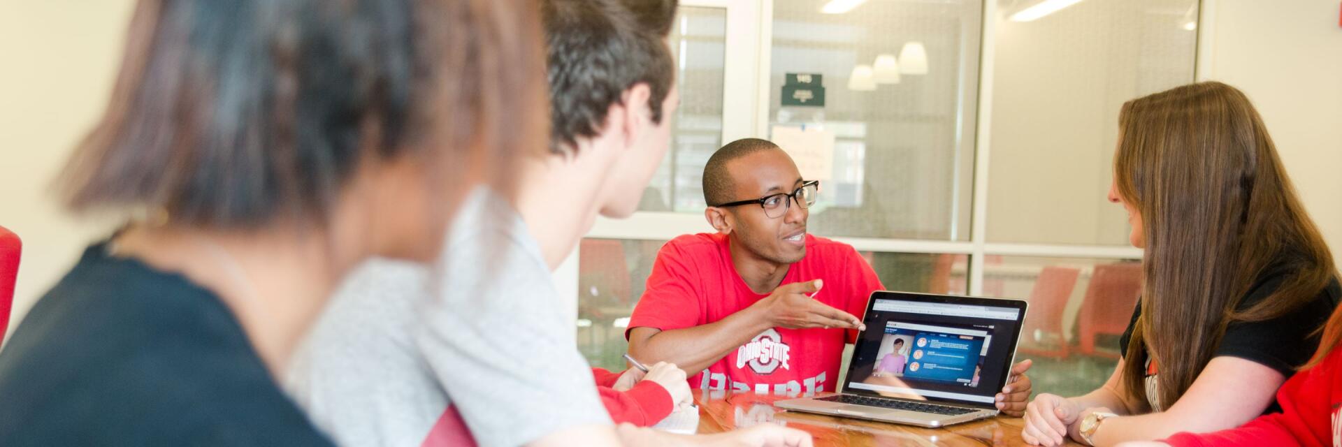 student discussing with students in a meeting room