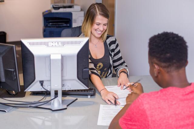 Student employee advising student at a desk