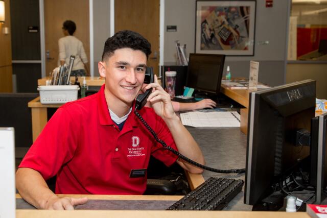 Student employee answering the phones at a desk